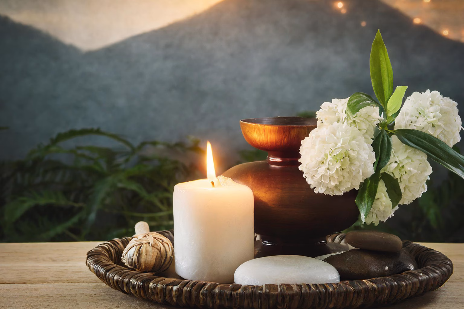 Peaceful wellness arrangement with a candle, white flowers, smooth stones, and natural elements symbolizing healing, resilience, hope, and emotional support for chronic illness and medical trauma.